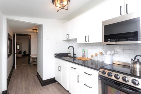 A kitchen with white cabinets and a black stove top.