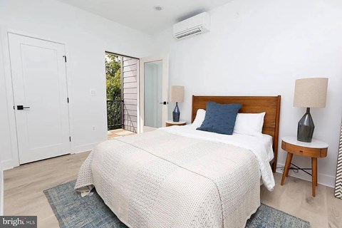 A bedroom with a large bed and a lamp on a side table.