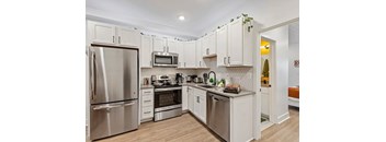 A kitchen with white cabinets and stainless steel appliances.