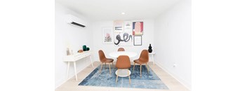 A dining room with a white table and chairs.