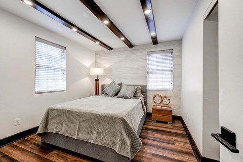 Bedroom with exposed wood beams and accent wall at The Tuscan Hills AHR LLC Apartments, Maryland