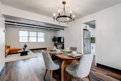 Dining area with wood table and upholstered chairs at The Tuscan Hills AHR LLC Apartments, Maryland, 21210