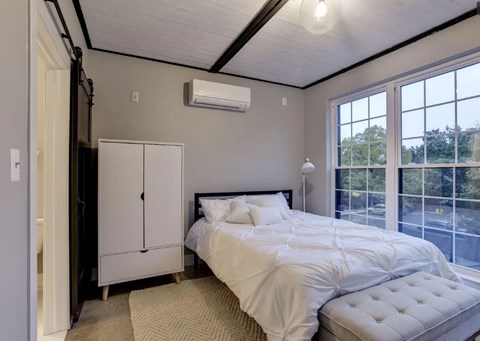 A bedroom with a large bed and a window overlooking a street.