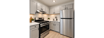 A modern kitchen with a stainless steel refrigerator, oven, and cabinets.