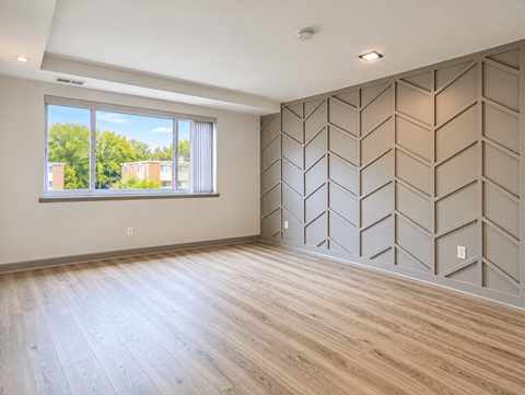 Spacious room with chevron accent wall at The Wyman Hills AHR LLC Apartments, Maryland