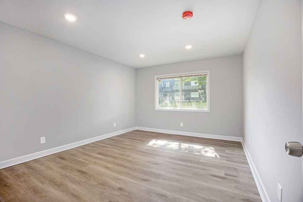 A room with a window and wooden flooring.at Palisades Apartments, Missouri