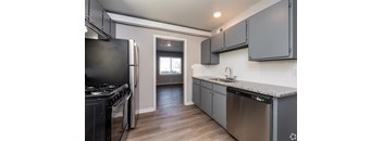 A kitchen with a stove top oven, dishwasher and a window. at Blacklark Apartments, Kansas, 66101