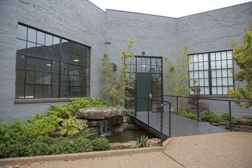 A modern building with a waterfall in the front yard.