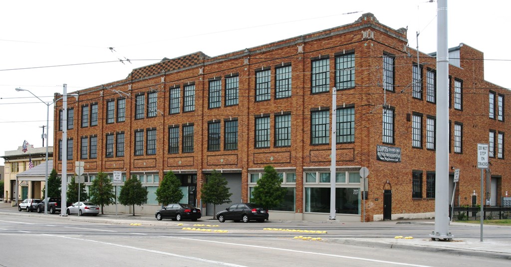 A large red brick building with a black awning on the front.