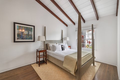 A bedroom with a bed, nightstand, and lamp.