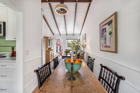 A kitchen with a long wooden table and chairs.