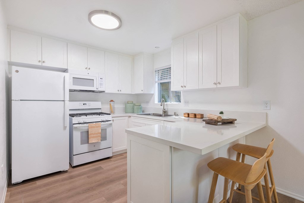 a kitchen with white cabinets and white appliances and a white counter top at The Aspens Fairhaven, Santa Ana