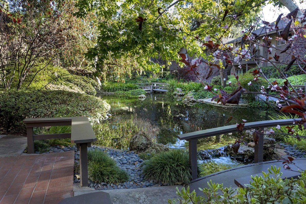 a view of a garden with a pond and benches at The Aspens Riverside, Riverside California