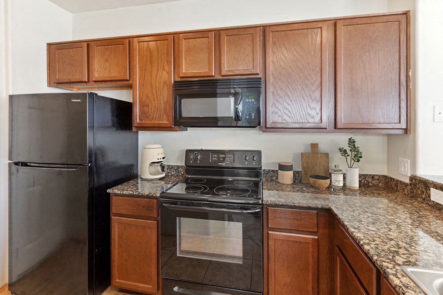 a kitchen with black appliances and granite counter tops