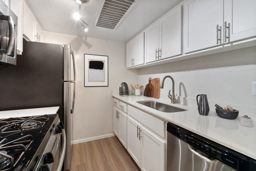 a kitchen with stainless steel appliances and white cabinets