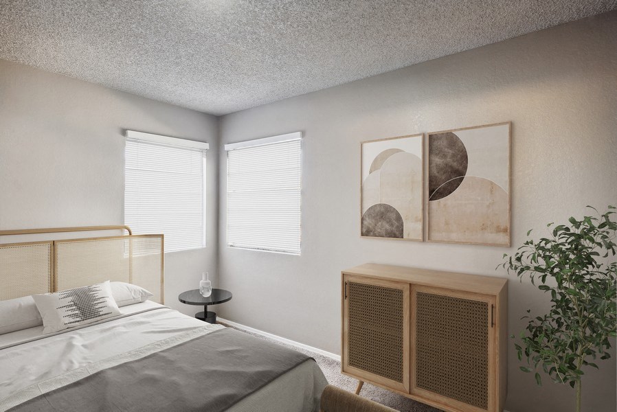 a bedroom with a bed and a table and two windows