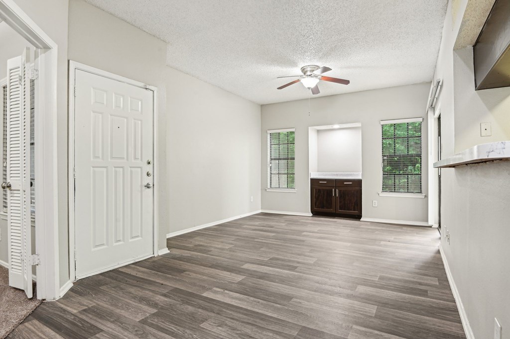 A room with a white door and a ceiling fan.