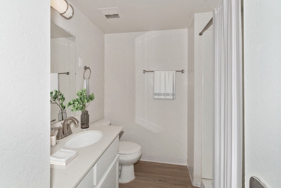 a white bathroom with a toilet and a sink