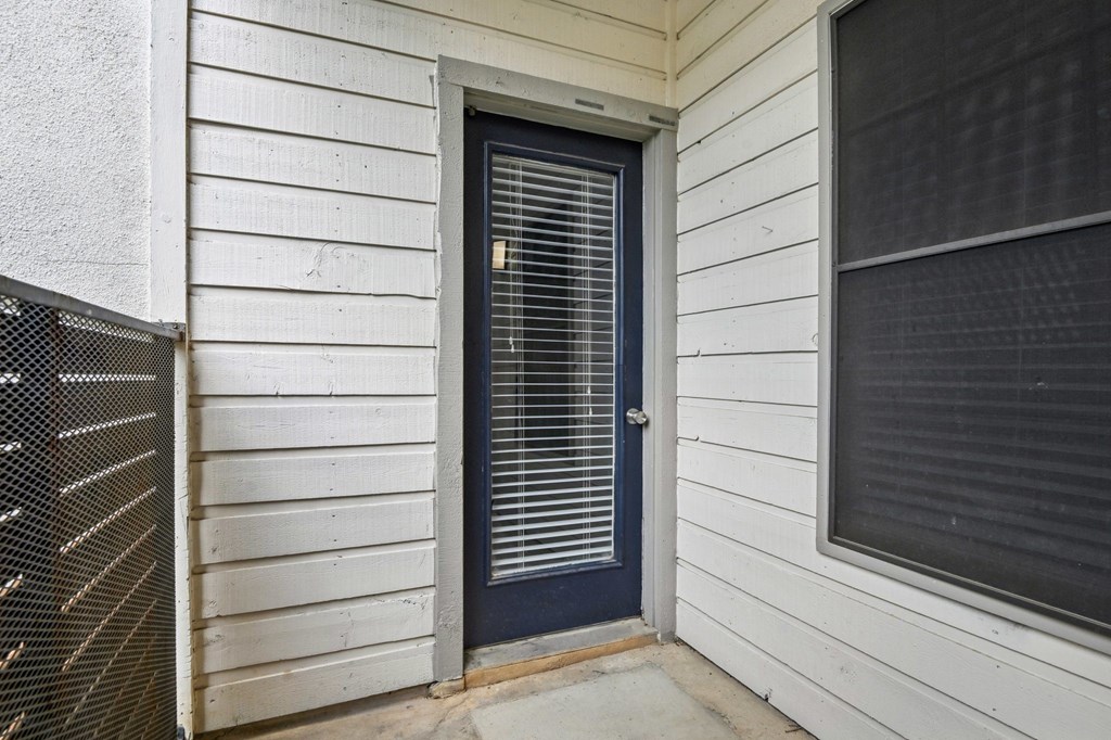 A white house with a dark blue door and window.