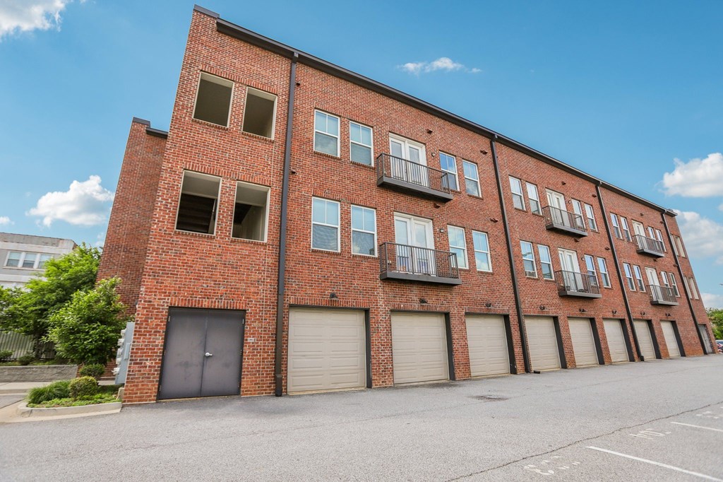 A red brick building with a parking lot in front.