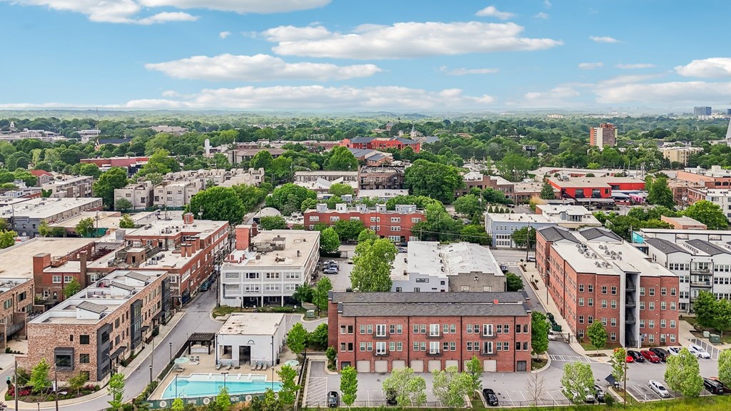 A cityscape with buildings and a pool in the foreground.