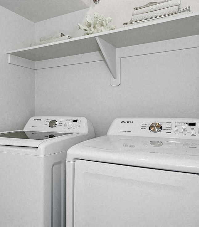 two white washing machines in a white laundry room