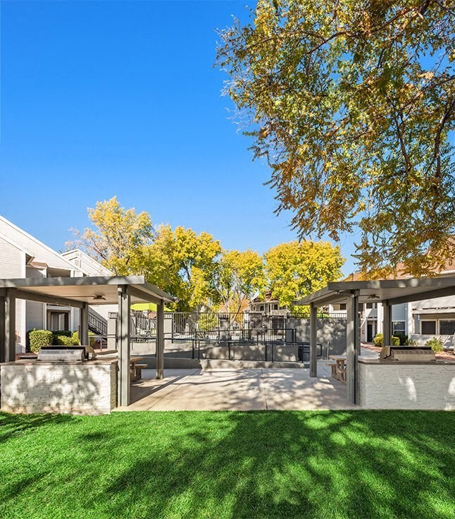 a backyard with a patio with shade structures