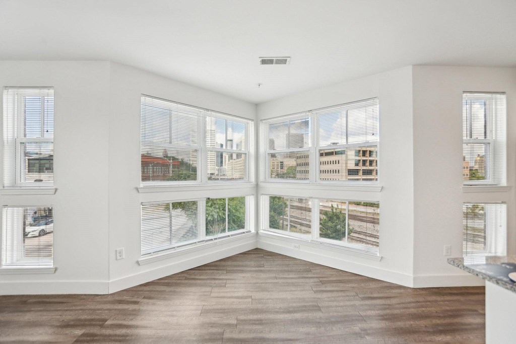 A room with a view of the city through large windows.