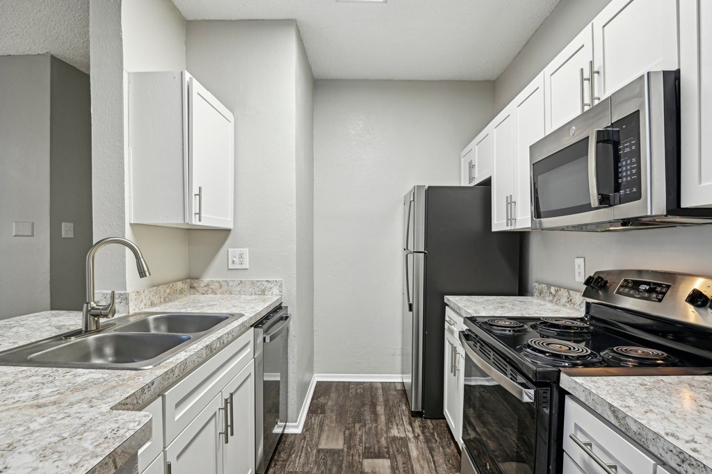 A kitchen with a black refrigerator, stove, and oven.
