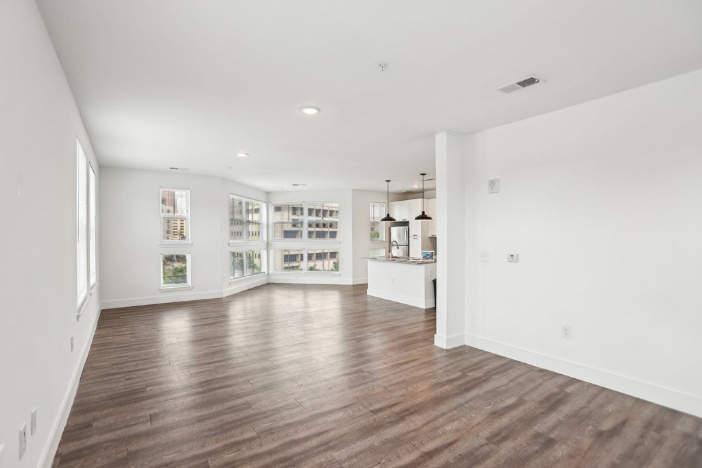A spacious room with wooden floors and white walls.