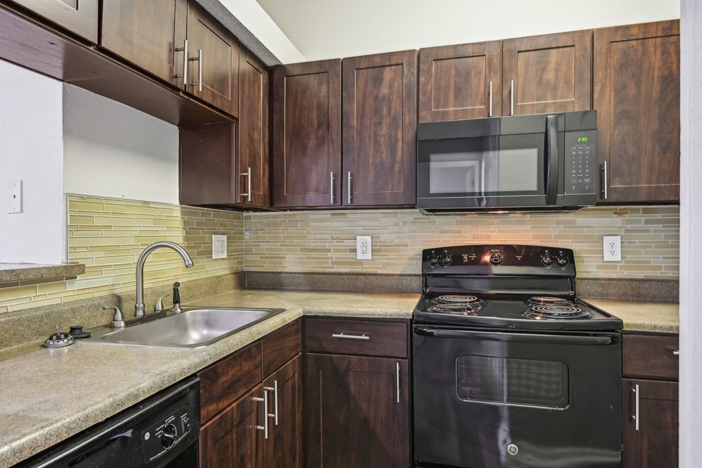 A black stove top oven with a microwave above it.