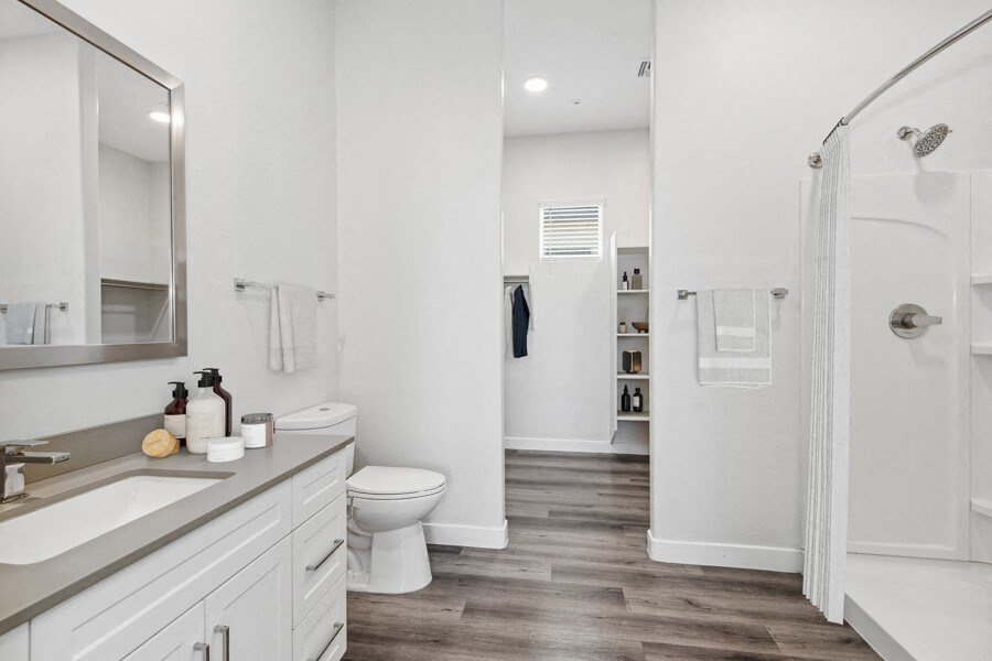 a white bathroom with a shower and a sink and a toilet