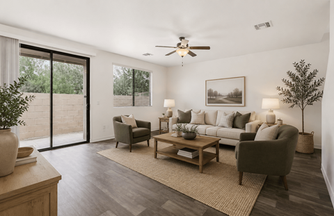 A living room with a grey couch, a wooden coffee table, and a ceiling fan.
