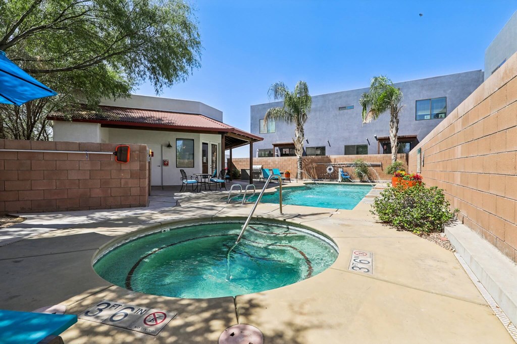 A pool with a slide and a house in the background.