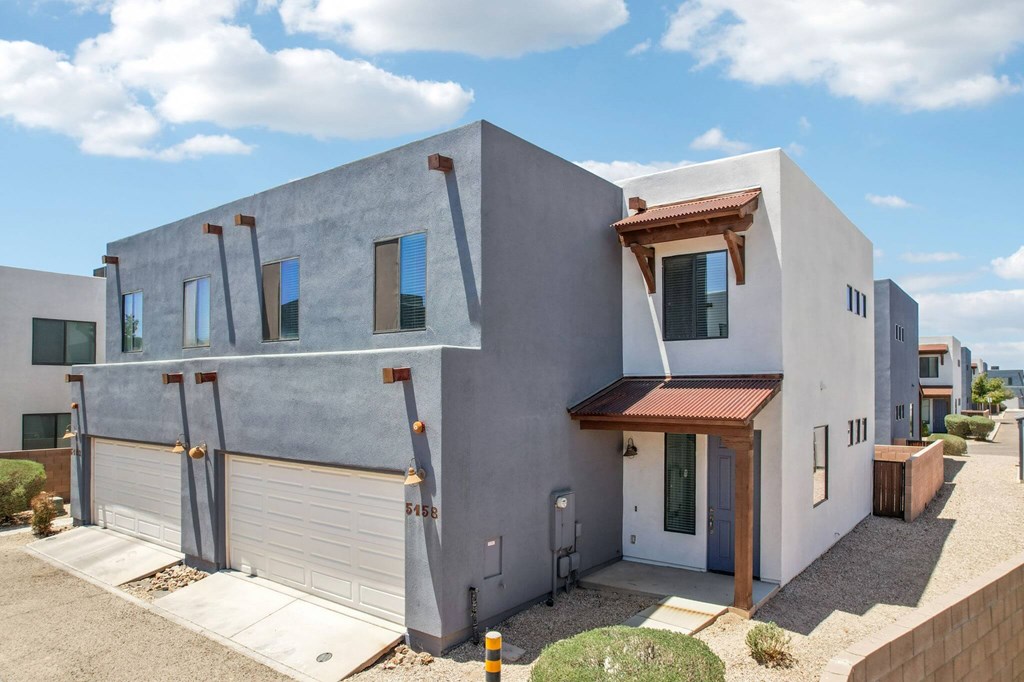 A modern house with a grey exterior and a red tile roof.