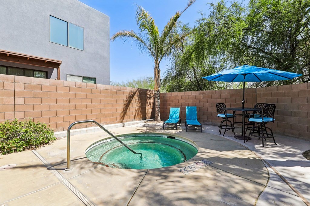 A small pool in a backyard with a table and chairs.