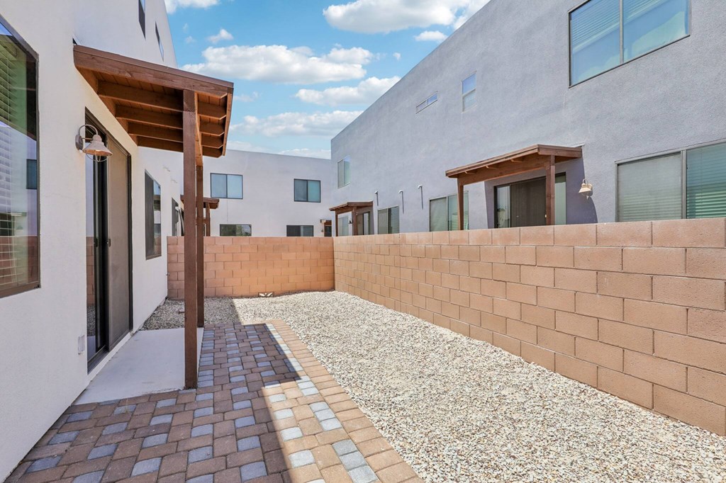 A modern building with a brick wall and a gravel pathway.