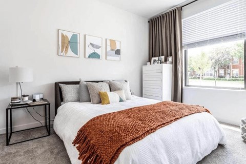 a bedroom with a bed and a large window