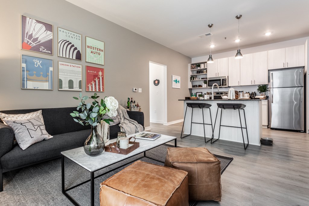 a living room with a couch and a table in front of a kitchen