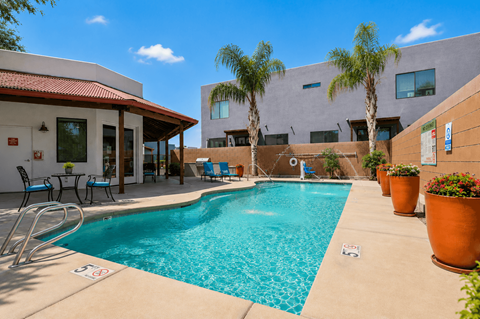 A pool with a red roof and a building behind it.