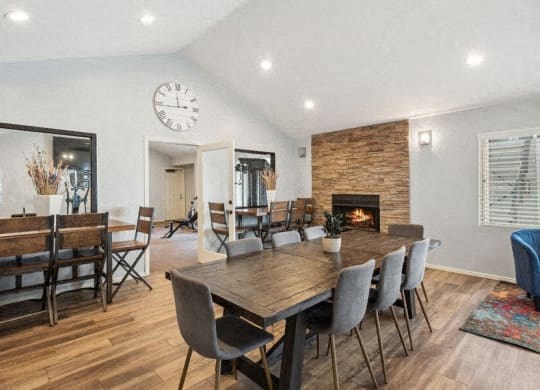 a dining room with a wooden table and chairs and a fireplace