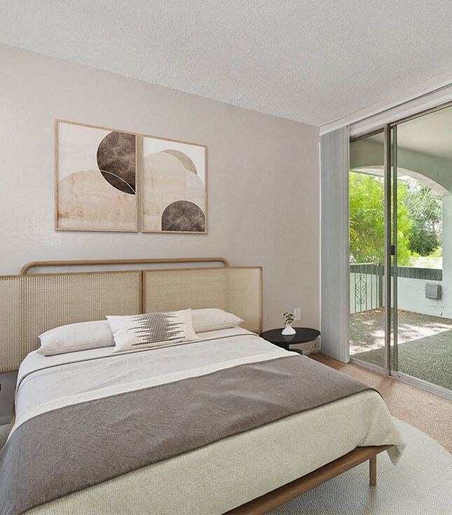 a bedroom with a bed and a sliding glass door