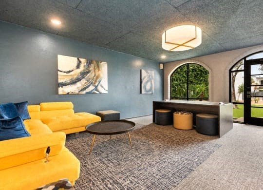 a living room with blue and yellow couches and a table