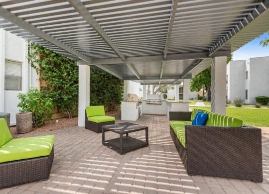 a patio with couches and a table under a roof