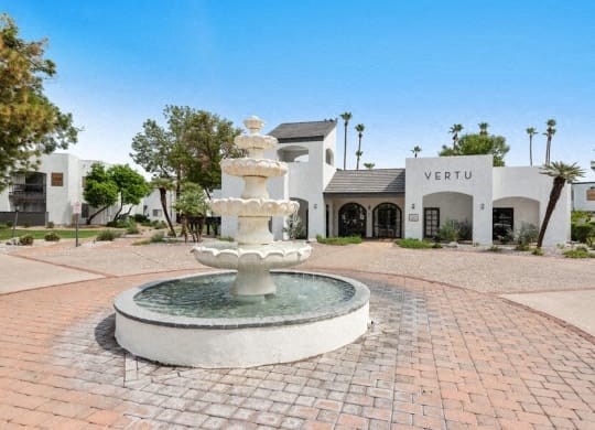 a fountain in front of a white building
