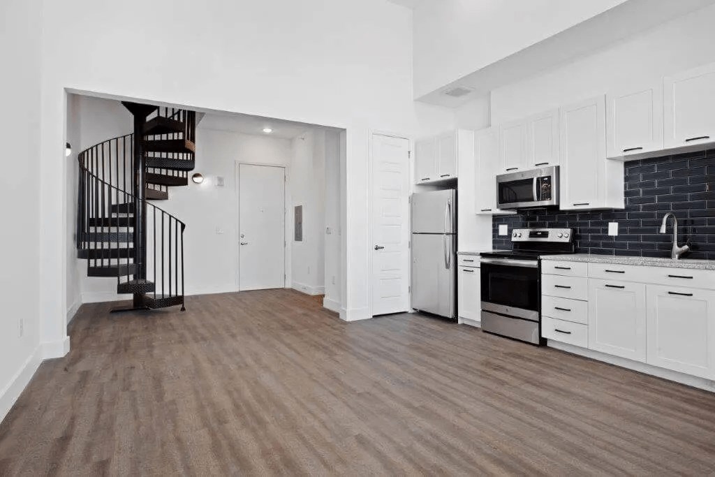 a white kitchen with a spiral staircase in the middle at Smith and Porter, Atlanta, GA