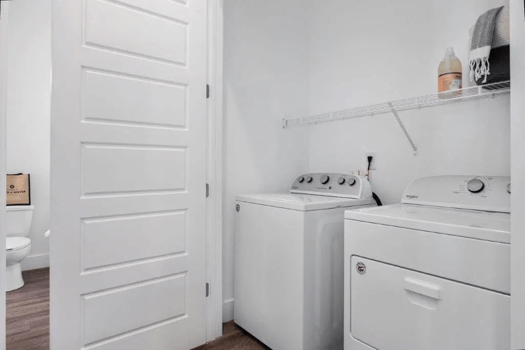 a small laundry room with a washer and dryer and a white door at Smith and Porter, Georgia