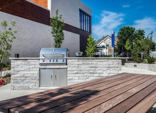 a barbecue grill on a stone wall outside of a building at Marcato, Kansas City, MO