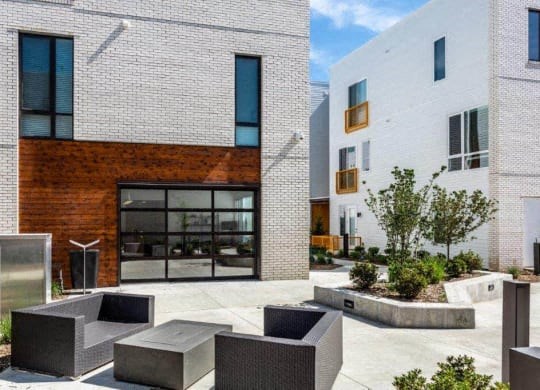 a courtyard between two buildings with benches and a glass door at Marcato, Kansas City, MO