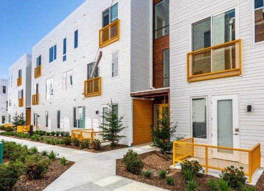 a row of apartments with balconies and a sidewalk at Marcato, Kansas City, MO, 64108